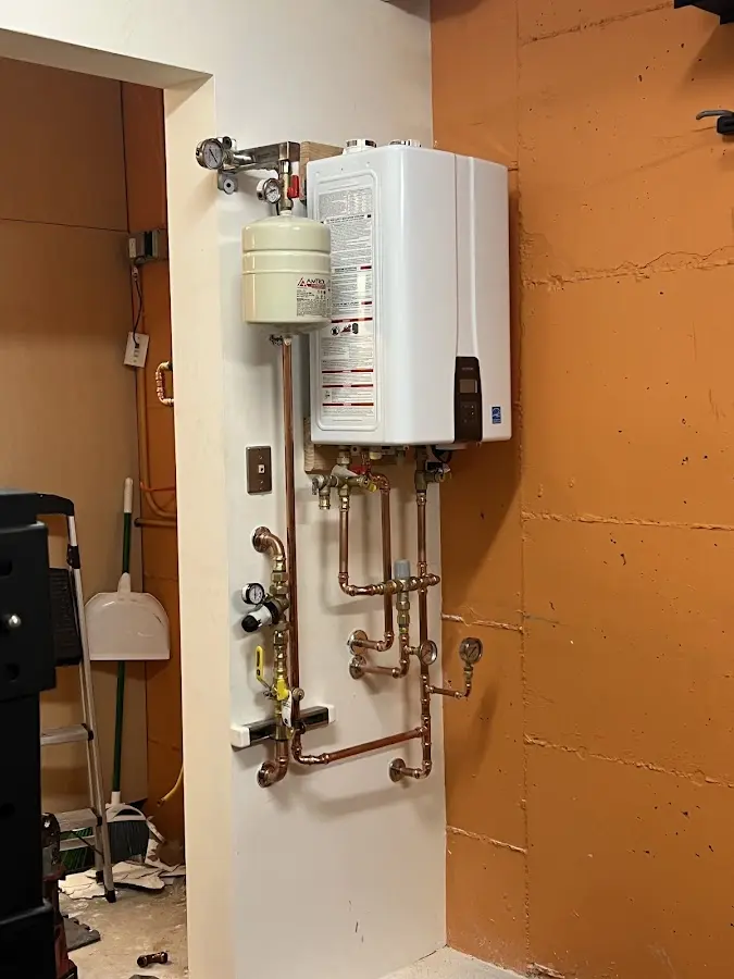 Plumbing technician inspecting water heater connections in Beechwood